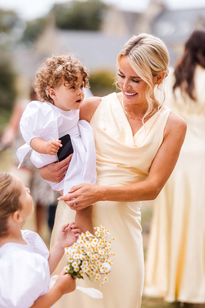 Bridesmaid in yellow outside a Cotswold church 