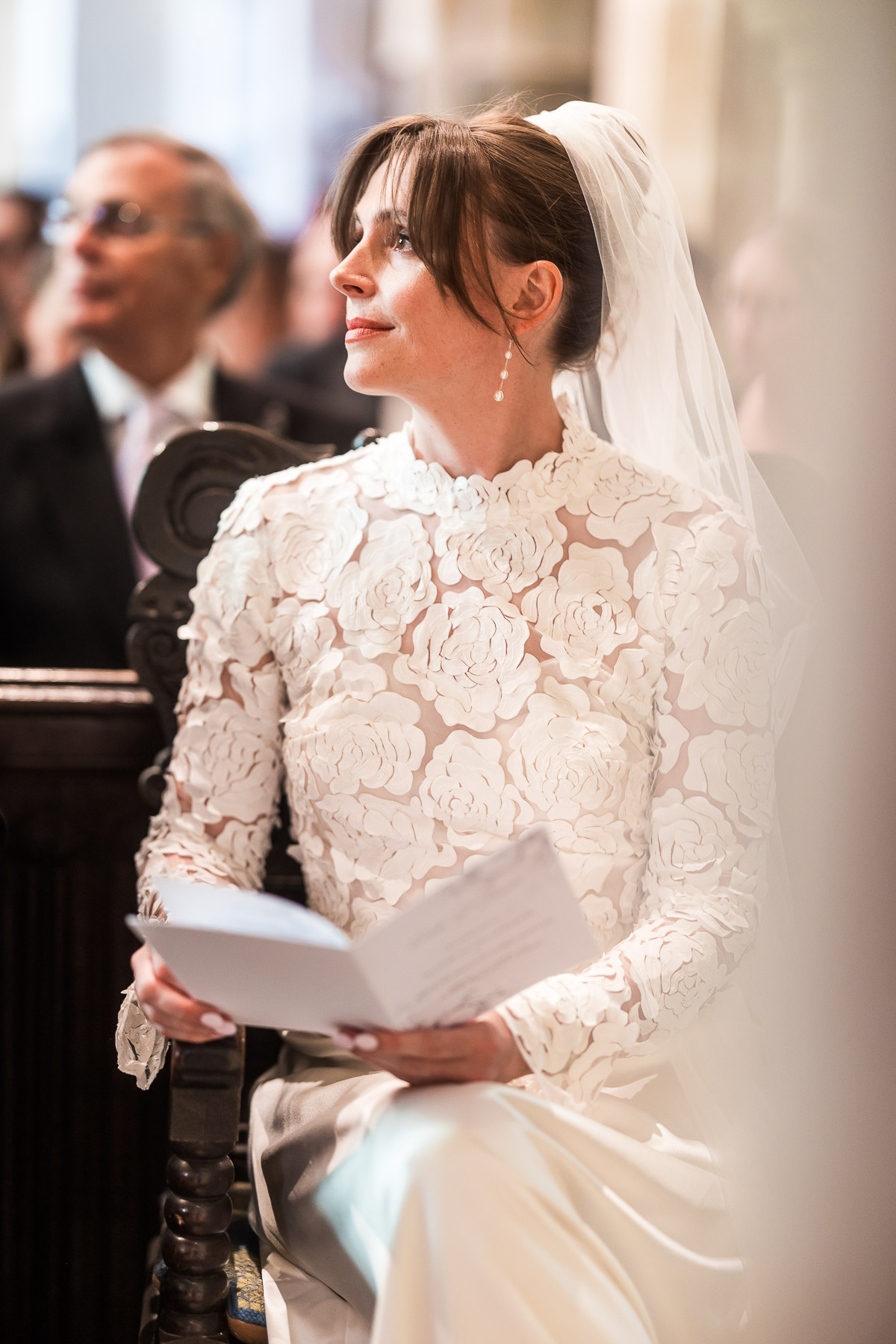 Bride sat watching someone do a reading in church 