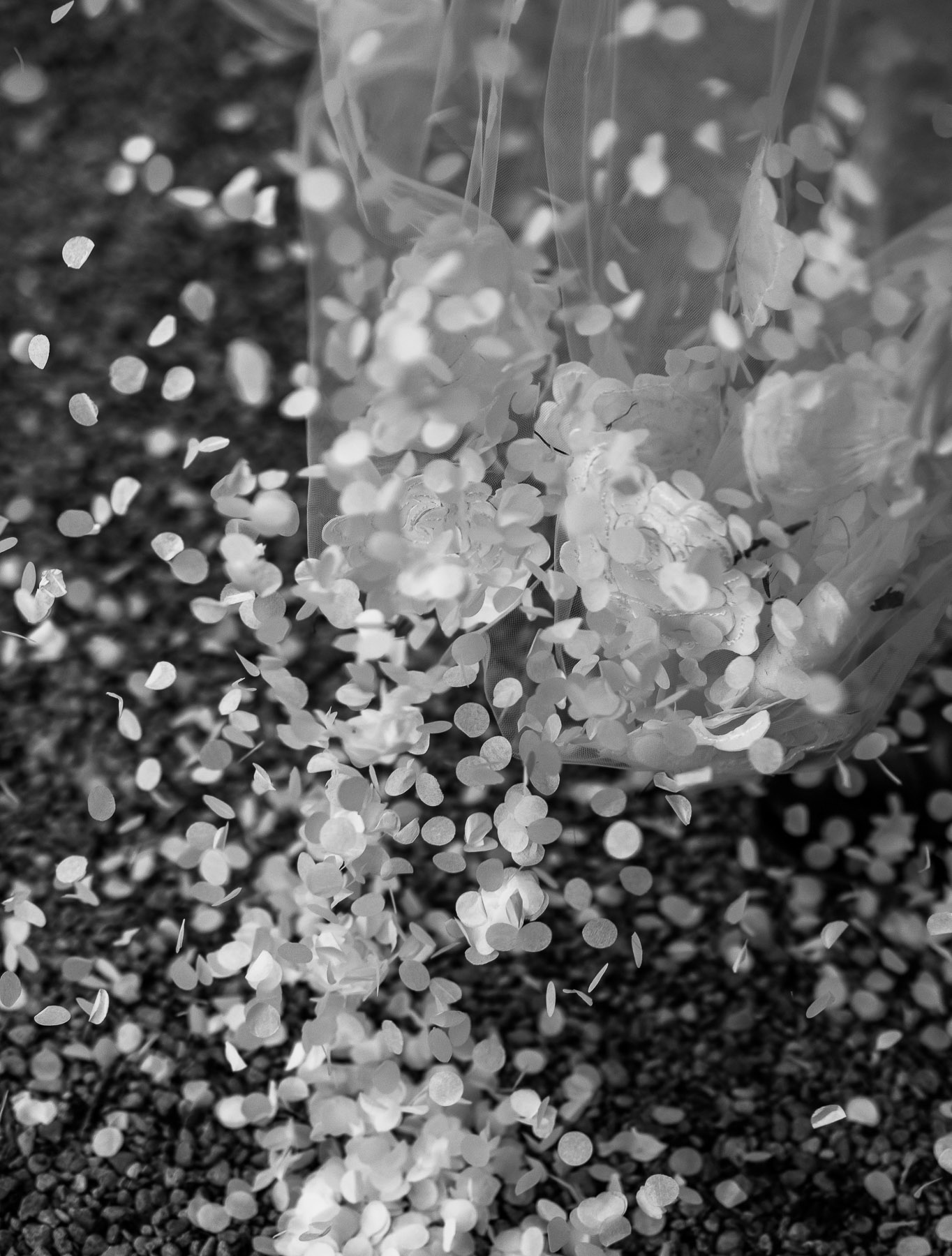 Editorial image of confetti spilling down a wedding dress 