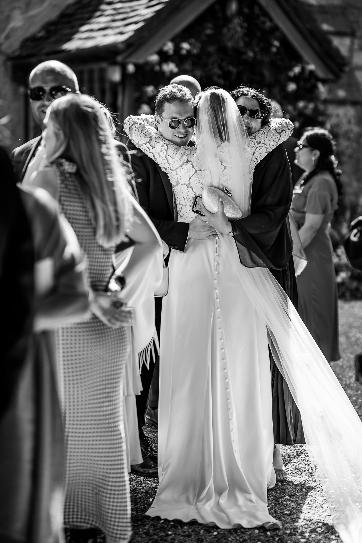Bride embracing her friends outside Elmore Church 