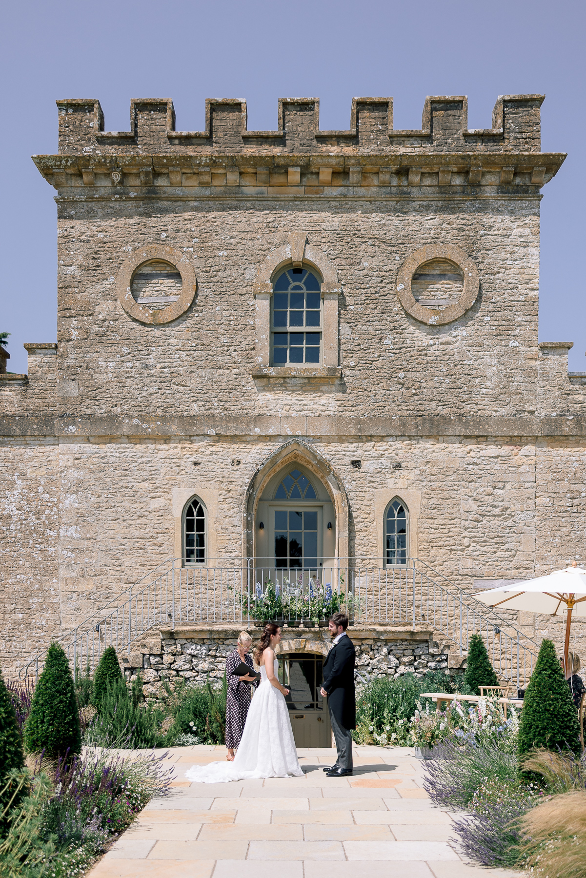 full length of bride and groom in front of Ivy Lodge 