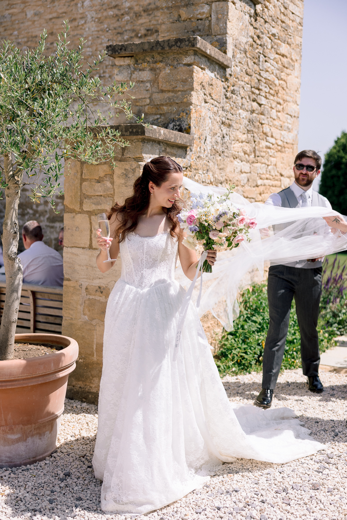 Bride walking her veil caught by the wind 