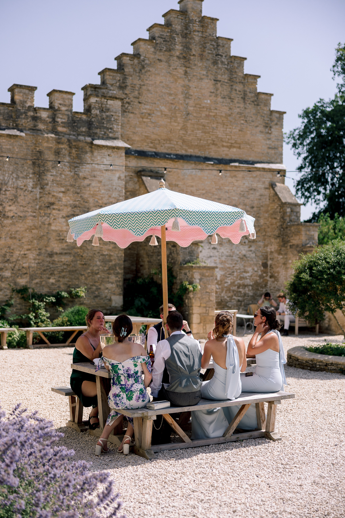 bridesmaids sat around under a parasol 