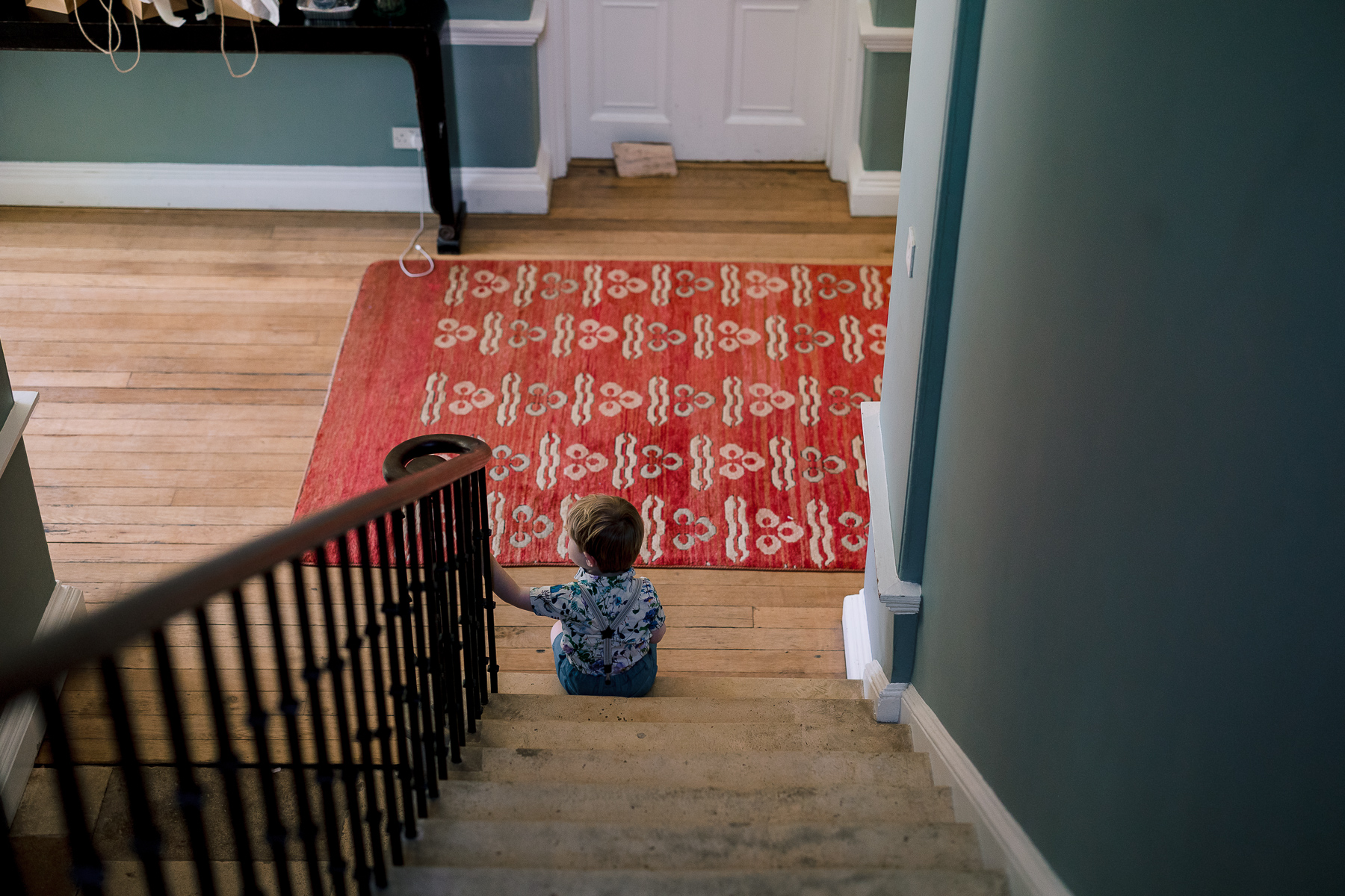 Little boy sat at the bottom of the stairs 