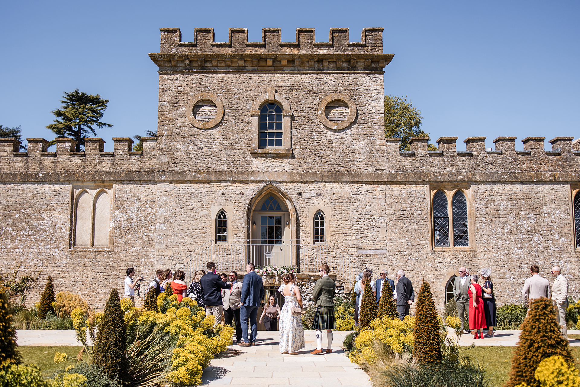 Front view of Ivy Lodge in Cirencester with guests standing outside in the sunshine