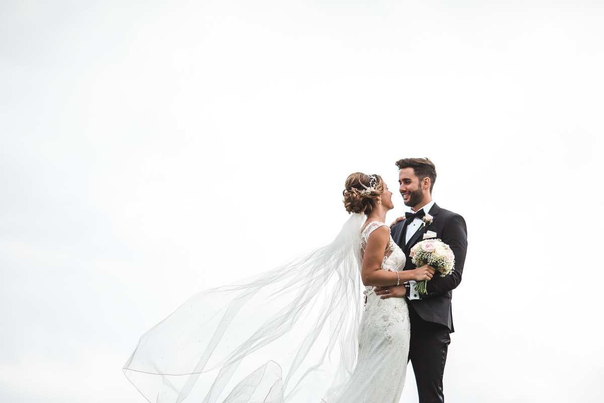 Couple standing with a white background at Kingscote Barn 